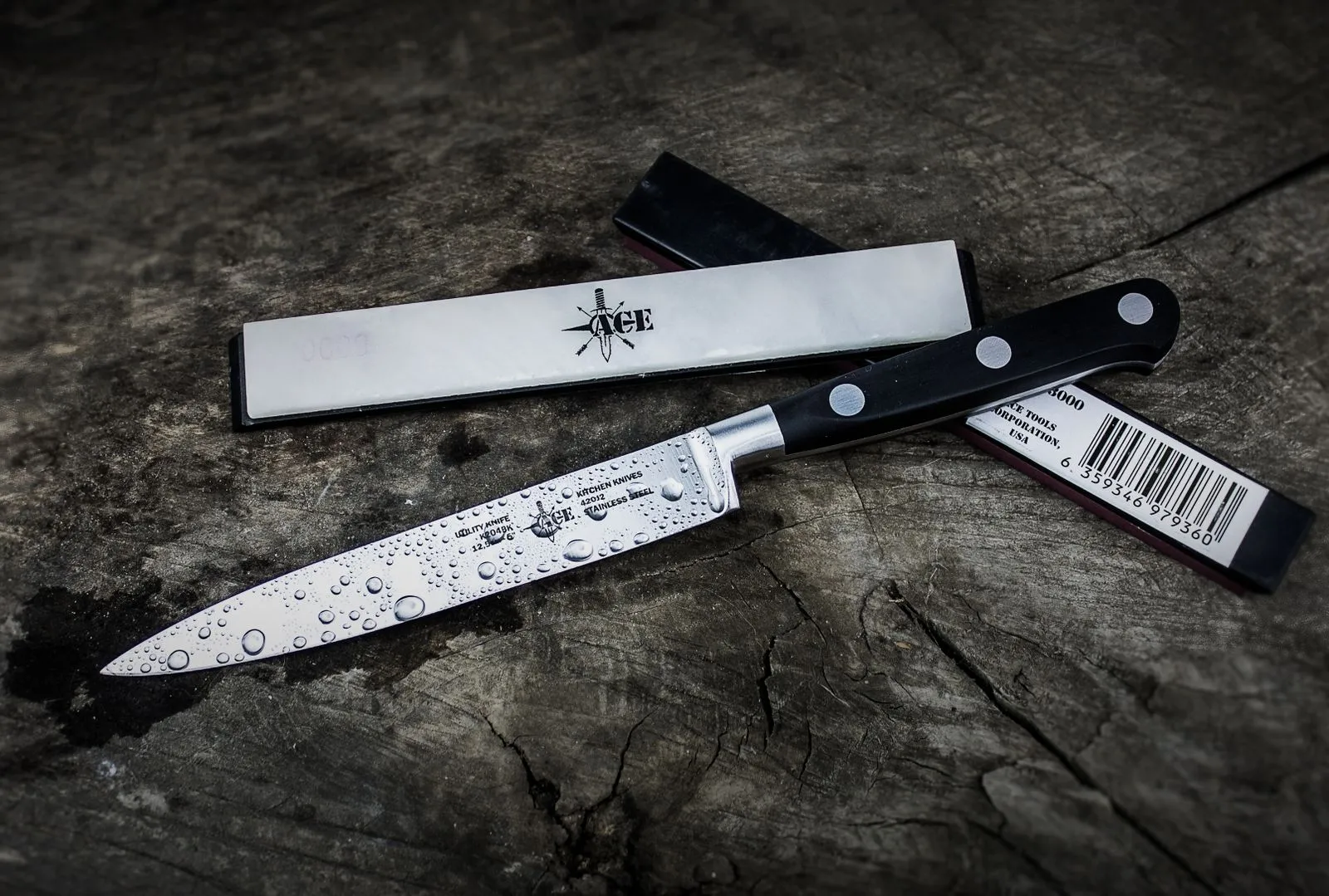 A sharp kitchen knife with water droplets on a rustic wooden surface, providing a dramatic mood.